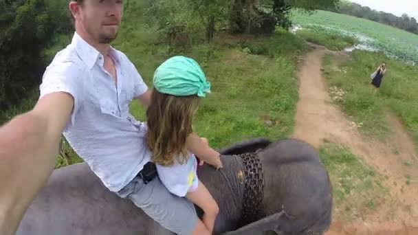 Cute blond girl enjoying elephant ride with her father in Sri Lanka. — Stock Video