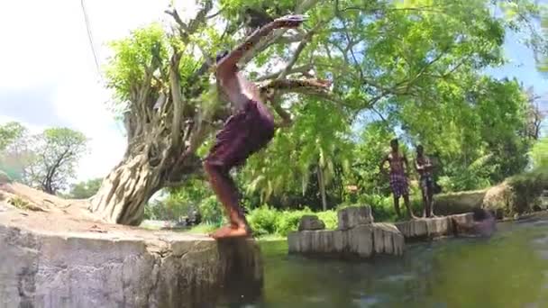 Jeune garçon faisant un saut périlleux en arrière dans la rivière . — Video