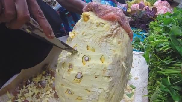 Femme coupant des fruits durian avec un gros couteau au marché du dimanche — Video