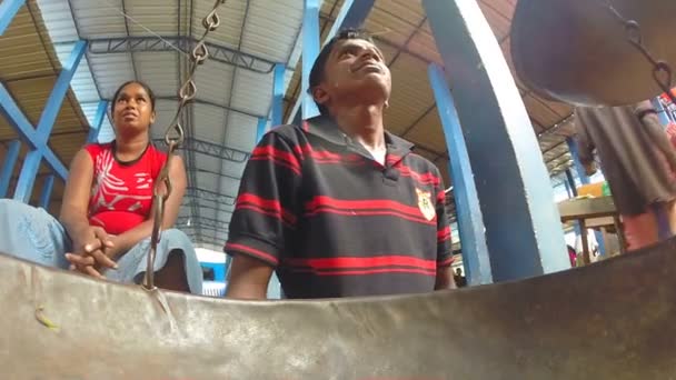 Hombre local sentado y esperando a sus clientes en el mercado — Vídeos de Stock