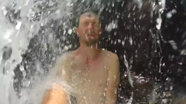 Man står under vattenfall — Stockvideo