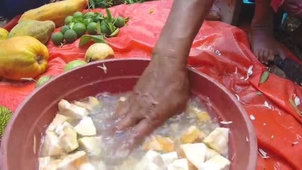 Lavaggio a mano fette di frutta affettate in ciotola d'acqua . — Video Stock