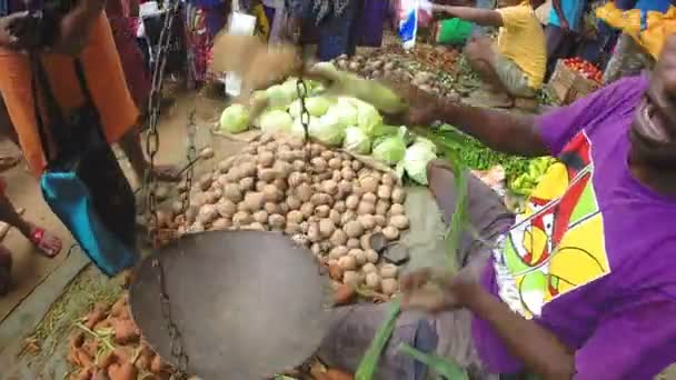 Местный житель взвешивает свои продукты на рынке — стоковое видео