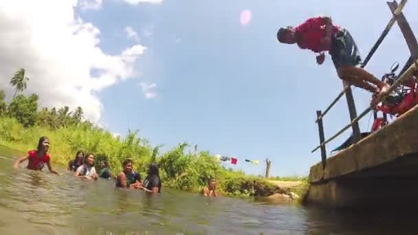 Chica joven saltando desde el puente en el río . — Vídeos de Stock