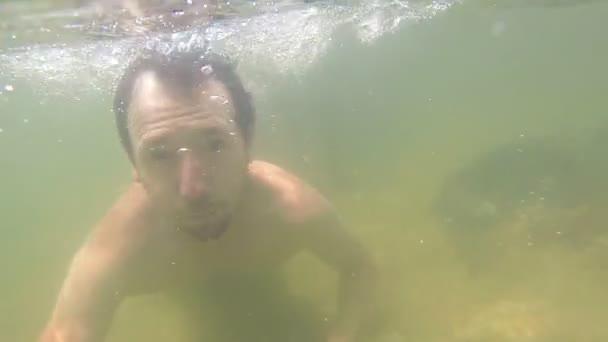El hombre se sumerge bajo el agua — Vídeos de Stock