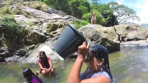 Mulher de pé no rio derrama água do balde sobre si mesma — Vídeo de Stock