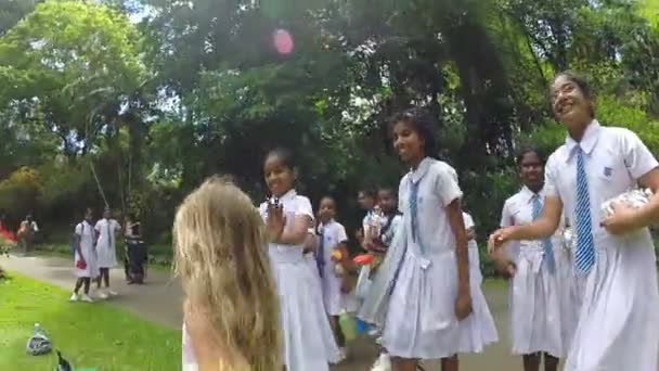 Schoolmeisjes poseren met Kaukasische meisje — Stockvideo