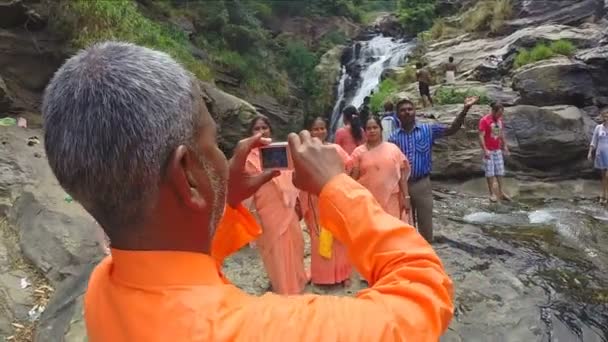 Man taking pictures while stands on the rocks. — Stock Video