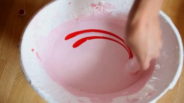 Beyaz boya kova içinde kırmızı boya karıştırma