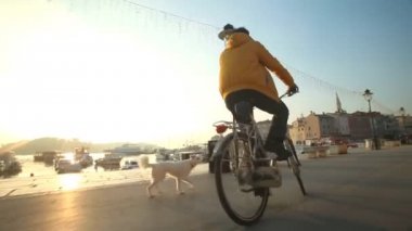 Adam yolda bisiklet sürüyor.