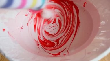 Beyaz boya kova içinde kırmızı boya karıştırma