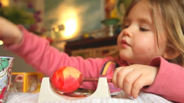 Девушка рисует яйцо на пасхальные праздники — стоковое видео
