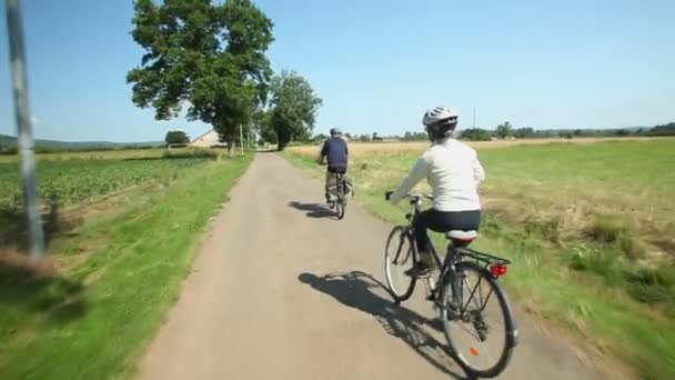 Retired couple cycling on road — Stock Video