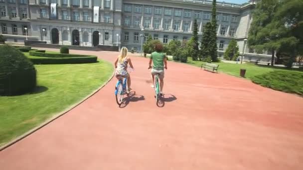 Par njuter av cykling genom park — Stockvideo