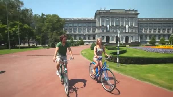 Ζευγάρι που απολαμβάνουν ποδηλασία μέσα από το πάρκο — Αρχείο Βίντεο
