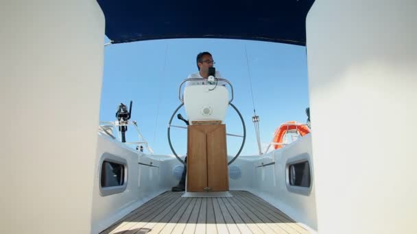 Man at wheel steering sailboat — Stock Video