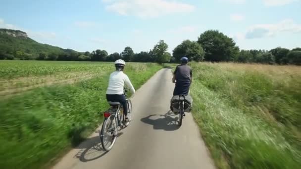 Emerytów para na rowerze na drodze — Wideo stockowe