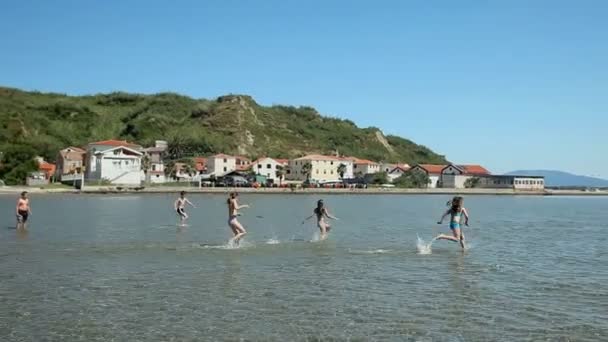 Children on school outing running in sea — Stock Video