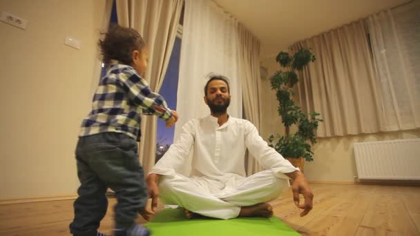 Мужчина с ребенком практикует йогу — стоковое видео
