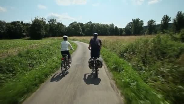 Pareja jubilada en bicicleta por carretera — Vídeos de Stock