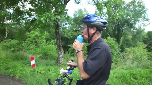 Мужчина-велосипедист отдыхает от выпивки — стоковое видео