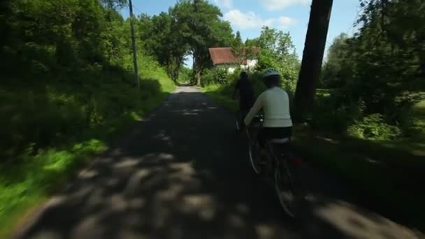 Couple retraité faisant du vélo sur la route dans le village — Video