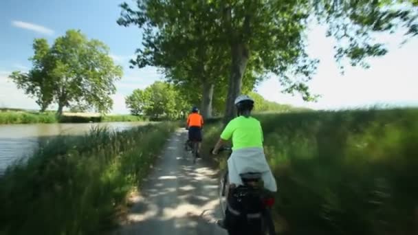 Důchodci pár cyklistické vedle řeky — Stock video