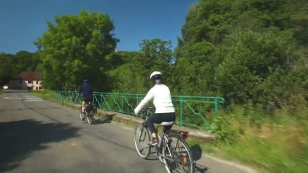 Pareja jubilada en bicicleta por carretera — Vídeo de stock