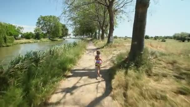 Little girl running along path track — Stock Video