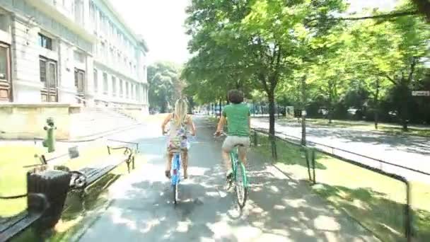 Paar genieten van fietsen door park — Stockvideo