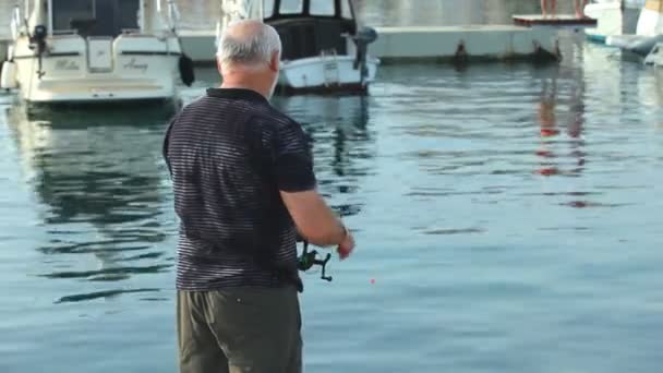 Visser in de oude stad Krk haven — Stockvideo