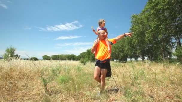 Grootvader boekwaarde kleindochter op schouders — Stockvideo