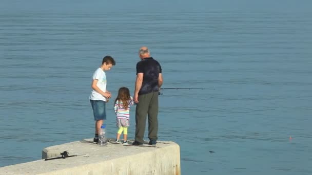 Family fishing in old town Krk harbour — Stock Video