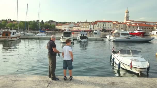 Vissers in de oude stad Krk haven — Stockvideo