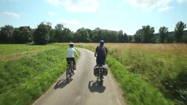 Сімейна пара катається на велосипеді по дорозі — стокове відео