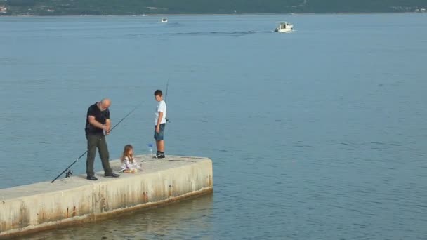 Family fishing in old town Krk harbour — Stock Video