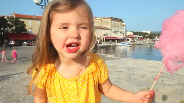 Linda niña comiendo hilo dental de caramelo — Vídeo de stock
