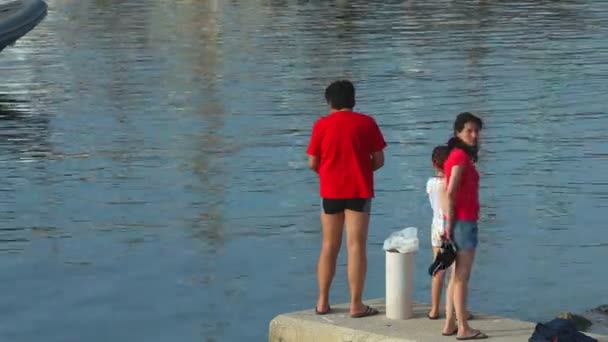 Toeristen lopen op haven muur — Stockvideo