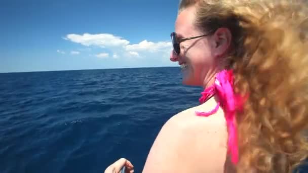 Kobieta siedzi na dziobie łodzi żaglowych, ciesząc się widokiem na morze — Wideo stockowe