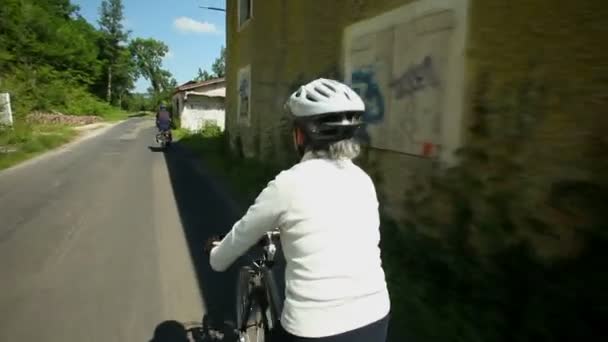 Woman cycling on road in countryside — Stock Video