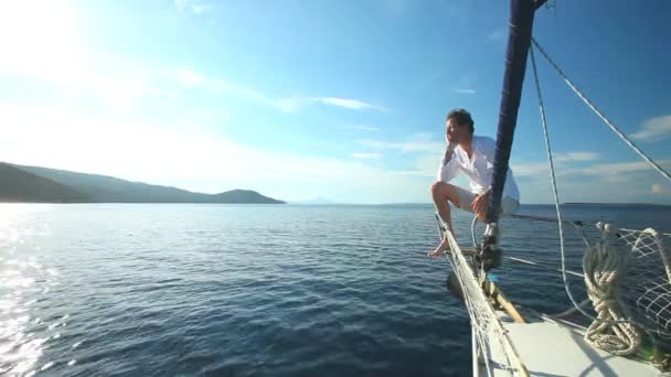 Man op de boeg van zeilboot — Stockvideo