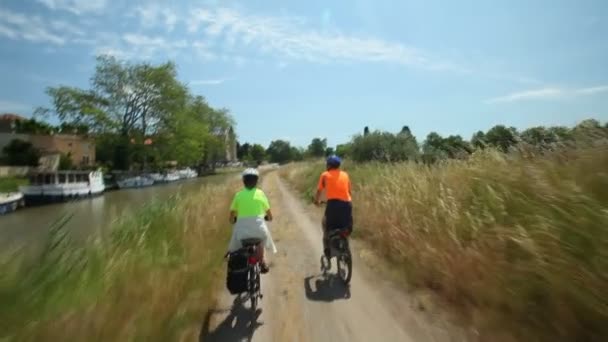 Důchodci pár cyklistické vedle řeky — Stock video