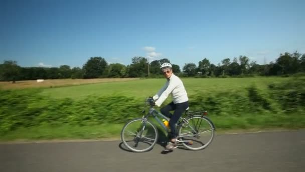 Woman cycling on road — Stock Video