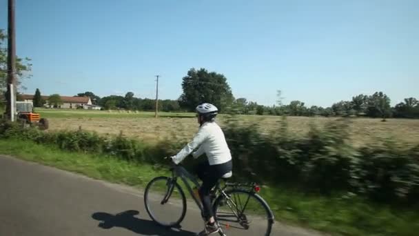 Vrouw fietsen op weg — Stockvideo