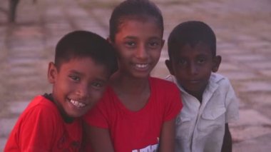 Sahilde oturan üç yerel çocuk