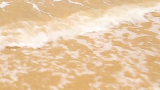 Vlny oceánu zahrnující slovo láska v písku na pláži — Stock video