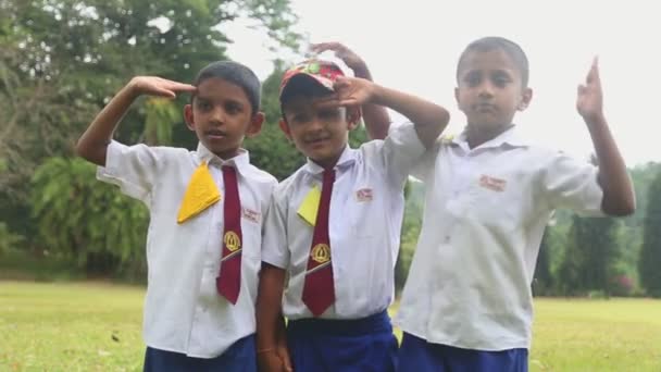 Crianças de uniforme escolar brincando nos Jardins Botânicos — Vídeo de Stock