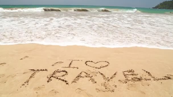 Ocean wave covering words I love travel written in sand on beach — Stock Video