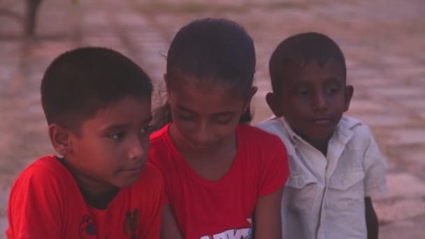 Three local kids sitting on a beach — Stock Video