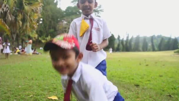 Kinderen in school uniform spelen in de botanische tuinen — Stockvideo